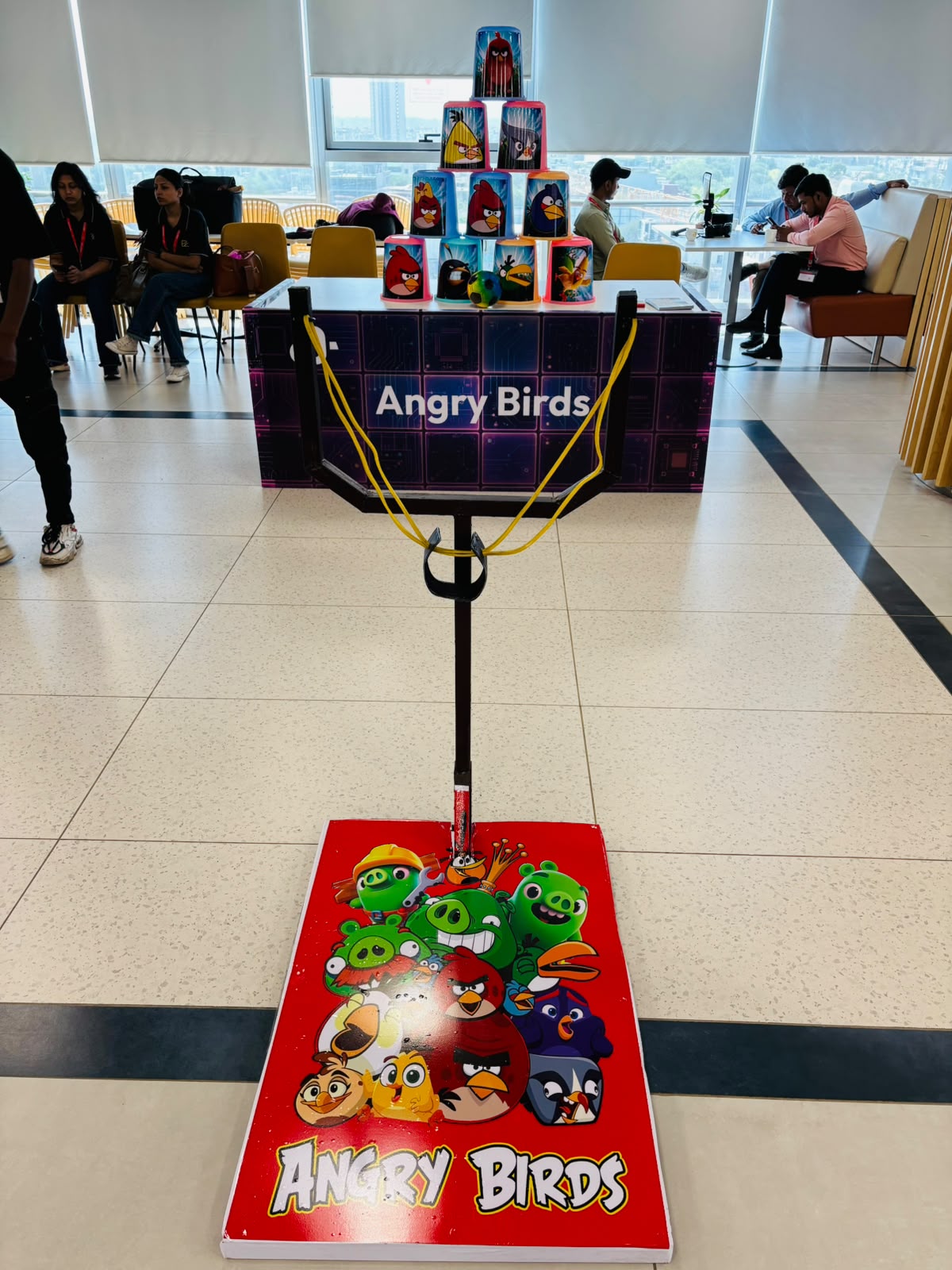 Interactive Angry Birds slingshot game rental with themed target cans and giant launcher for corporate events, family days, shopping mall activations, exhibitions, roadshows, and experiential marketing by Fabx Events.